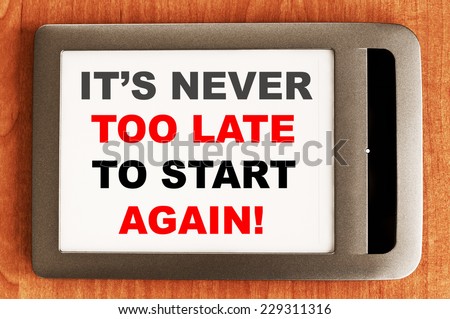 It\'s never too late to start again written in e-book Motivational concept