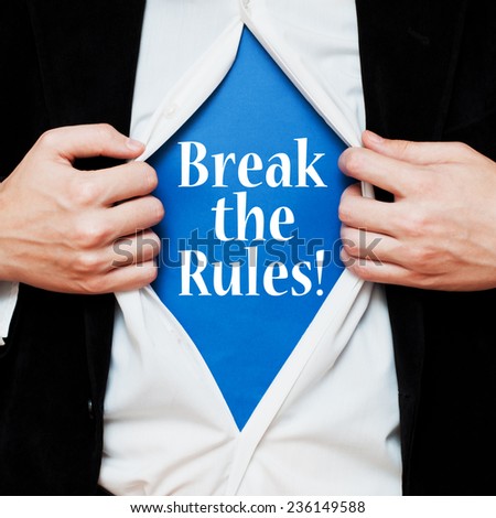Break the Rules! Businessman showing a superhero suit underneath his shirt with a motivational message text written on it.
