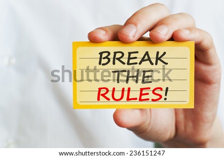 Break the Rules! Man holding a card with motivational message text written on it