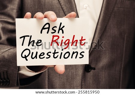 Ask The Right Questions - businessman holding a card with a message text written on it