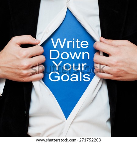 Write Down Your Goals. Businessman showing a message text under his shirt like superhero, tearing his shirt off