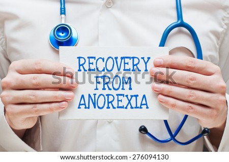 Recovery from Anorexia Written on a Card in Hands of Medical Doctor