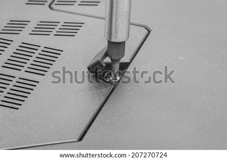 Repairing laptop: screw driver and bolt, close image.