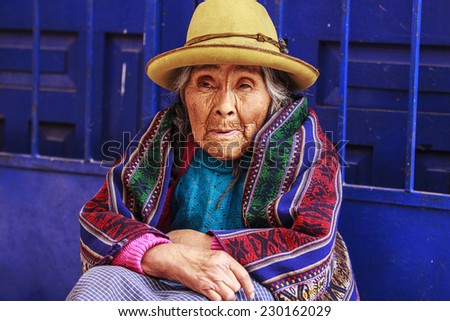 LIMA, PERU - October 12, 2013: Old Peruvian lady sitting on streets with a traditional Alpaca textile clothes.