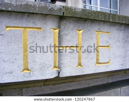 The word the in large gold letters carved in masonry