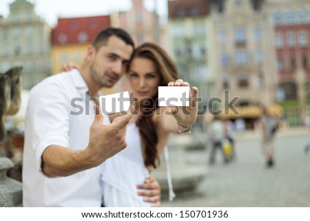 Portrait of blurred couple showing white card