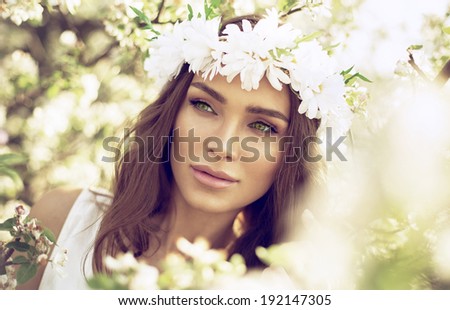 Beautiful woman with green eyes in the garden of apple