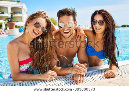 Group Of Smiling Friends Having Fun In Swimming Pool And Wearing Sunglasses