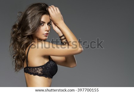 Sensual beautiful woman in lingerie posing. Girl with long curly hair