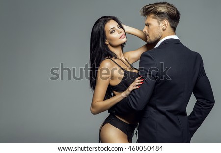 Portrait of sexy woman wear lingerie and hugging handsome man in black suit