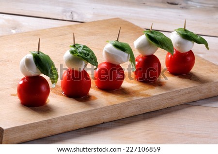 Caprese salad, typical Italian appetizer with mozzarella cheese, tomato, basil, oil, oregano