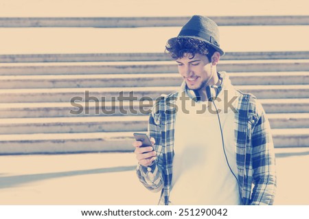 young stylish bearded man in Hoodie checkered shirt listening music in the city instagram style