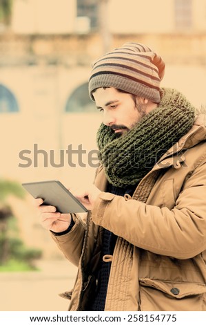 young man holding a tabet n Mediterranean Country instagram filte applied