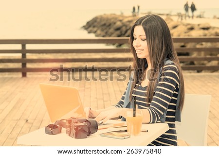 woman with useful digital devices to connect outdoors during a working session warm filter applied