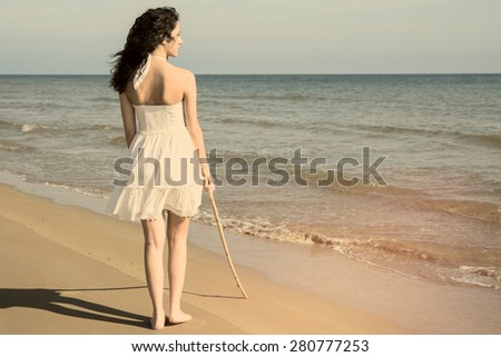 nice young woman walking on the beach warm filter applied