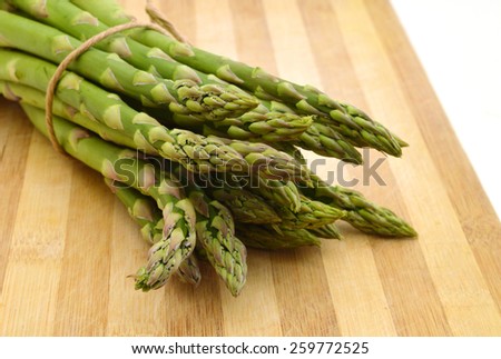 Bunches of asparagus tied with twine on a wood background. Overhead view in horizontal format.