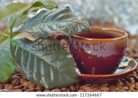 Cup of coffee, coffee leaves, coffee beans close-up