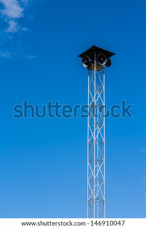 Speakers on the metal pole tower for announcement with blue sky background