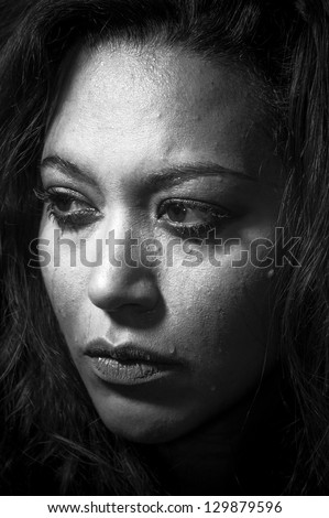 Depressed girl in tears with bad make-up concept in monochrome