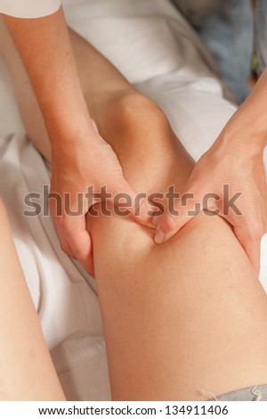 A physio gives myotherapy using trigger points on athlete woman