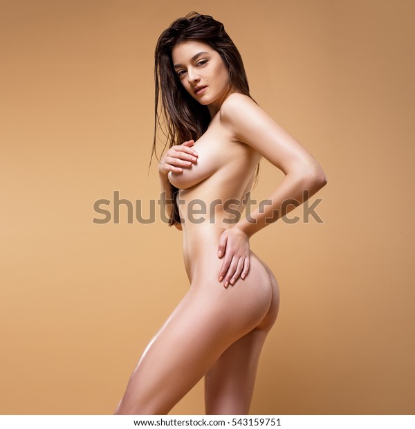 Beautiful Naked Woman Posing Isolated On The Beige Background