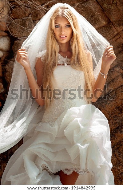 Beautiful Sexy Blonde Woman In Wedding Dress With White Veil And Long Hair And Tanned Body