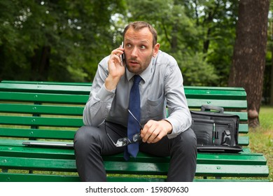 Businessman Sitting On Bench Chatting On Stock Photo 159809630