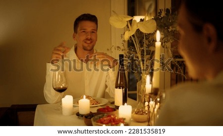 Cheerful man talking candles dinner close up. Brunette guy speaking at romantic anniversary date. Smiling gentleman chatting with woman silhouette. Male person conversation. Life relaxing time