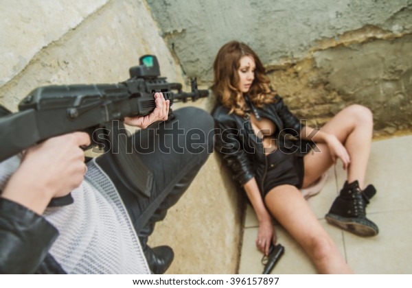Меган Дэниэлс позирует с пистолетом и ружьем 