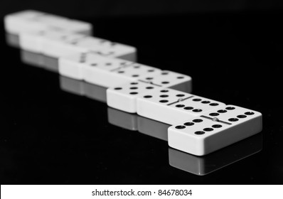 Dominoes On Black Shining Surface Reflection Stock Photo