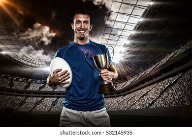 Portrait Smiling Rugby Player Holding Trophy Stock Photo