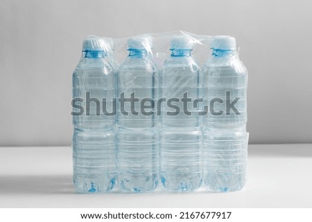recycling, packing and storage concept - close up of plastic bottles with pure drinking water on table