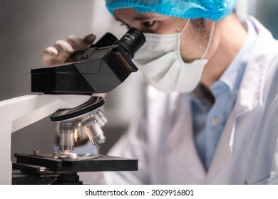 Scientist Looking Through Scientific Microscope Lense Stock Photo