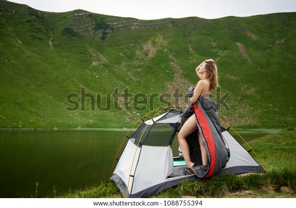 Side View Of Sporty Naked Woman Standing In Tent Entrance In Sleeping