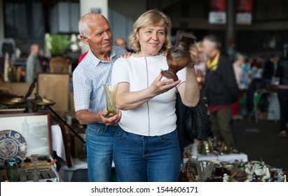 Smiling Mature Spouses Buying Retro Handicrafts Stock Photo