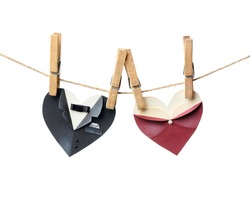 Symbolic male and female heart shapes hanging on the clothesline. Isolated on white. Wedding or st.Valentine theme.