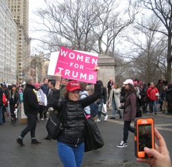 New York City, New York / USA - January 20 2018: A Trump supporter at that Women's March in New York City holds a pink sign that says, "Women for Trump".