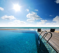 Swimming pool near the beach at high class resort in thailand for relax relaxation beautiful sea sand sun blue sky in Thailand