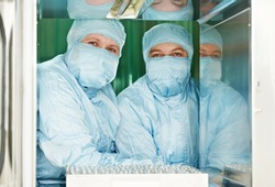 two pharmaceutical factory woman workers in protective workwear and masks at pharmacy industry manufacture factory