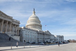 WASHINGTON, DC - JANUARY 20, 2018: People walk and jog past the United States Capitol on the first day of the government shutdown while the Capitol Police watch for threats.