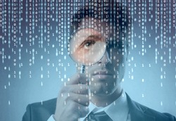 Young businessman observing a binary code on a screen through a magnifying glass