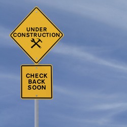 Under construction sign on a blue sky background (with copy space). Applicable for website and web page status updates.