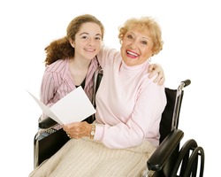 Teen girl gives greeting card to her grandmother for mothers day or other holiday.