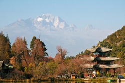 Ancient pagoda at the Black Dragon Pool Park, in front of Jade Dragon Snow Mountain in Lijiang, Yunnan Province, China.