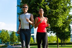 Urban sports - couple jogging for fitness in the city on a beautiful summer day