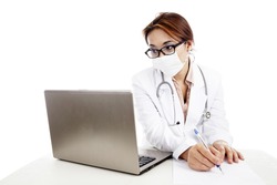 Female doctor with stethoscope and laptop writing on the paper to make a prescription. isolated on white