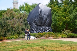 CHARLOTTESVILLE, VA–August 25, 2017: A couple stand in front of the tarp shrouded statue of Robert E. Lee in a Charlottesville park where Civil War statues have become a point of contention.