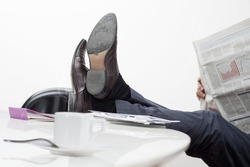 manager with feet on desk and cup of coffee