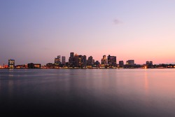 Boston downtown at dusk with urban buildings illuminated at dusk after sunset.