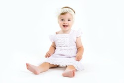 Adorable little baby girl laughing, creeping & playing in the studio, isolated on white background